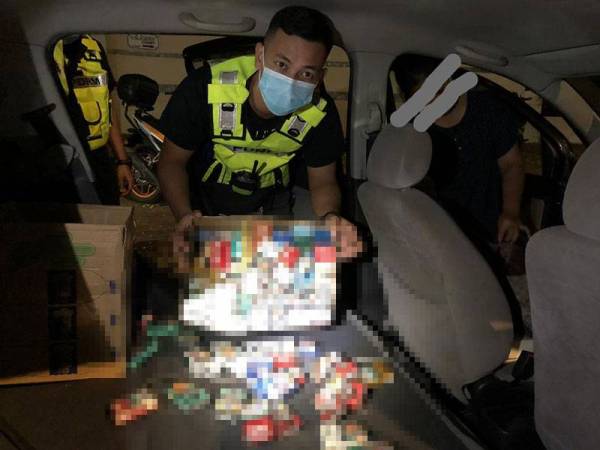 Anggota polis menunjukkan rokok seludup yang ditemui.