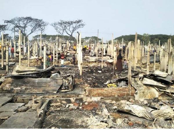 Beberapa pelarian Rohingya mencari barang milik mereka yang mungkin terselamat dalam kebakaran di kem pelarian Nayapara di Teknaf pada Khamis. - Foto AFP