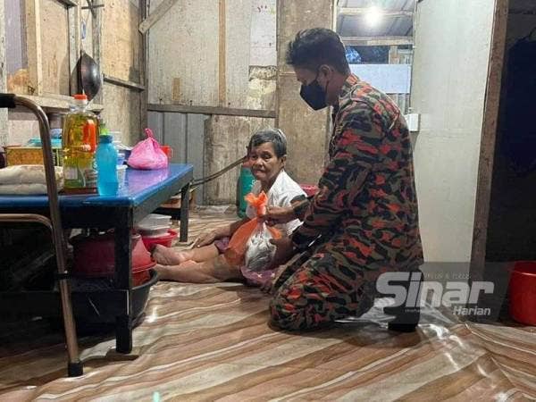 Anggota bomba mengagihkan sebahagian daripada 70 kilogram ikan yang disumbangkan Bulan Sabit Merah Johor kepada mangsa banjir dan Covid-19 di kawasan yang terjejas banjir di seluruh Johor.