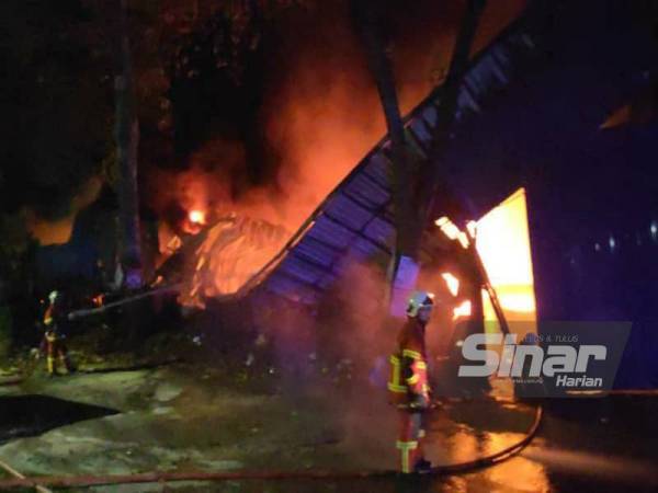 Anggota bomba bertungkus lumus memadamkan kebakaran di lokasi kejadian di Jalan Genpita 7, Taman Salak Selatan, Kuala Lumpur awal pagi Sabtu.