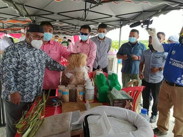 Mohd Khairuddin (kiri) menunjukkan produk-produk yang dihasilkan daripada kenaf selepas menyempurnakan Majlis Pelancaran Ladang Rakyat Kenaf PPPNP di Ladang Gugusan Lambor pada Ahad.