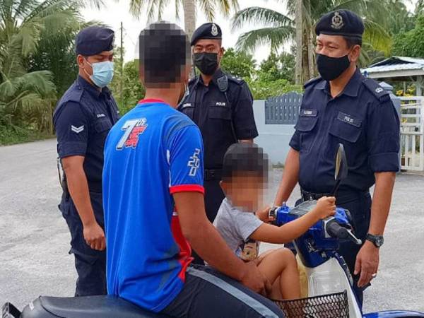 Mohd Azmir (kanan) menyoal siasat seorang bapa bersama anaknya yang gagal mematuhi SOP dalam tempoh perlaksanaan PKP.