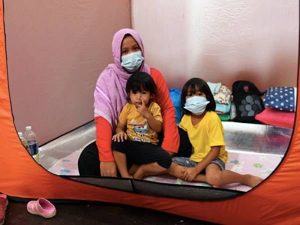 Mangsa banjir Baili Binti Baya bersama anak-anaknya dari Kampung Labakingan turut dipindahkan ke pusat penempatan mangsa banjir di Dewan Tun Said, Kota Belud hari ini. - Foto Bernama