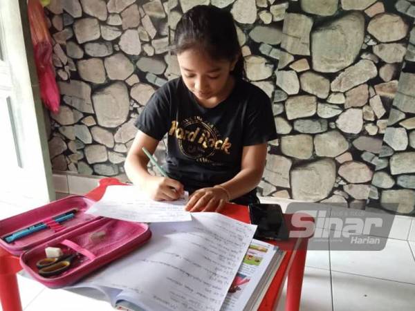 Sharifah Aina Safiyya Syed Mohd Fazli, 10, yang menggunakan telefon pintar terpaksa menyalin latihan diberikan guru menerusi PdPR berikutan tiada mesin pencetak di rumahnya di Batu Tiga, Shah Alam. - Foto pembaca Sinar Harian