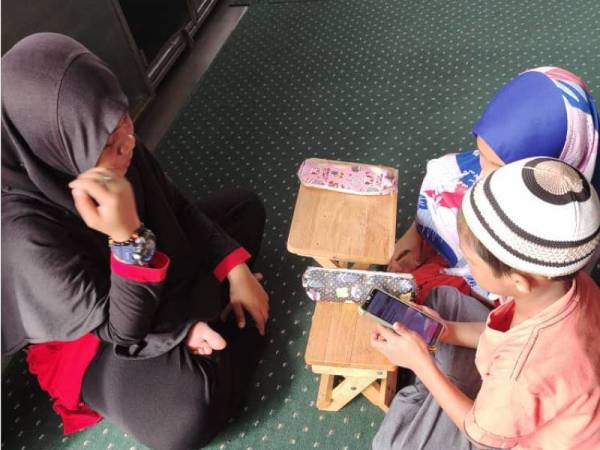 Penghuni Pertubuhan Kebajikan Dan Bimbingan At Taqwa terpaksa bergilir-gilir berkongsi telefon bimbit bagi mengikuti sesi PdPR.