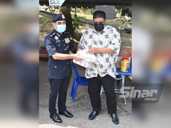 Speaker Dewan Undangan Negeri (DUN), Datuk Seri Ab Rauf Yusoh menyerahkan kit makanan kepada barisan hadapan yang diwakili Abdul Majid di SJR Plaza Tol Ayer Keroh, di sini, pada Rabu.