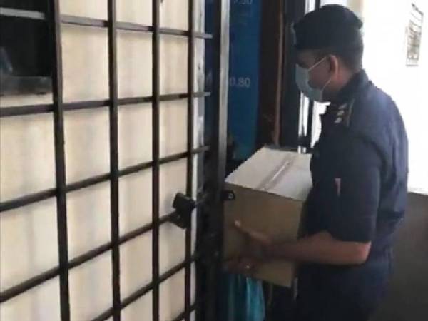 Nik Ezanee menyerahkan bakul bantuan JKM kepada seorang wanita di sebuah PPR di Petaling Jaya pada Khamis.