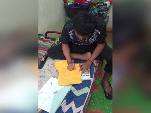 Shafizul Hafizzie Mat Sawin, 15, terpaksa belajar menggunakan buku sementara menunggu giliran menggunakan telefon bimbit untuk sesi PdPR di rumah di Kampung Suasa, Beaufort.