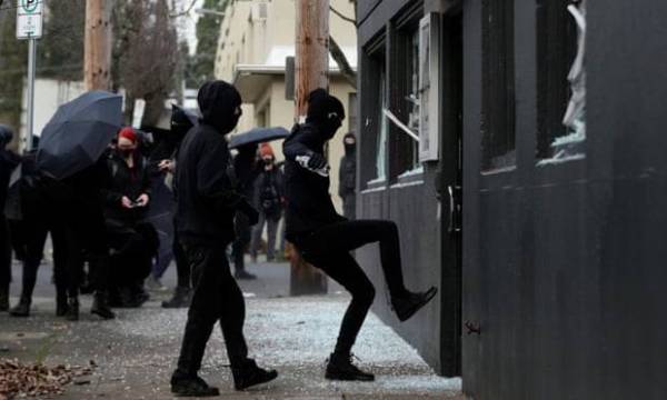 Dua perusuh merosakkan pintu hadapan bangunan ibu pejabat Demokrat di Portland.