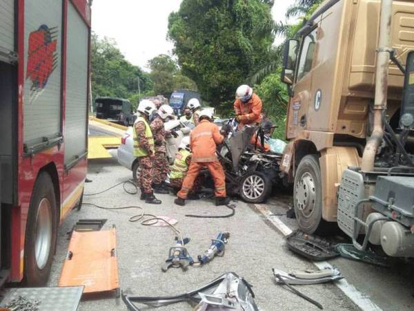 Anggota bomba menjalankan operasi mengeluarkan mayat mangsa yang tersepit dalam nahas di Tapah pada Jumaat. Foto: Ihsan PDRM