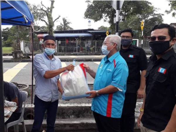Hassan menyampaikan bantuan barang keperluan asas kepada peniaga, Mohd Khairy Masnor di Taman Desa Harmoni, Plentong, Pasir Gudang pada Sabtu.