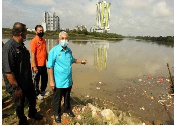 Hassan menunjukkan sampah sarap di Sungai Tebrau, Kampung Plentong Baru, Pasir Gudang yang masuk ke perairan Singapura pada Sabtu.