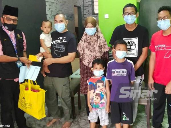 Wakil Jejak Asnaf MAINJ, Nasir Ishak (kiri) menyampaikan sumbangan kepada Mohd Sayeed Haron ketika mengadakan lawatan ke rumahnya di PPR Melana, Tampoi, Johor Bahru.