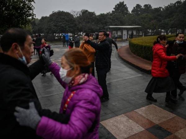 Beberapa pasangan warga emas menari bersama di sebuah taman di bandar tersebut. - AFP