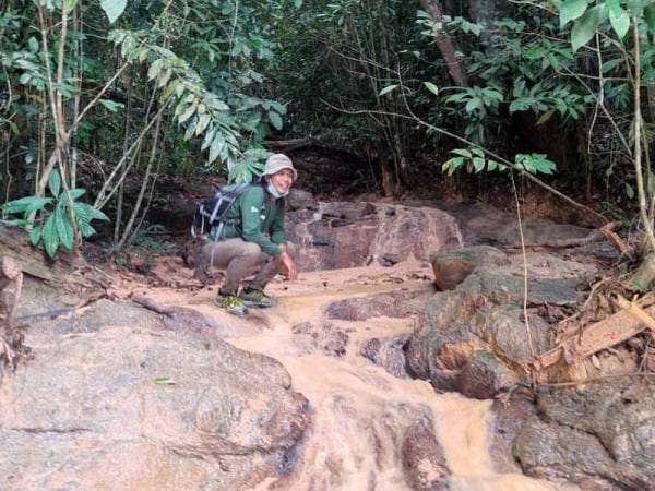 Ismady menunjukkan laluan anak sungai Teluk Akuan yang terjejas menyebabkan airnya keruh kesan campuran tanah merah. - Foto FB Otai Manjung