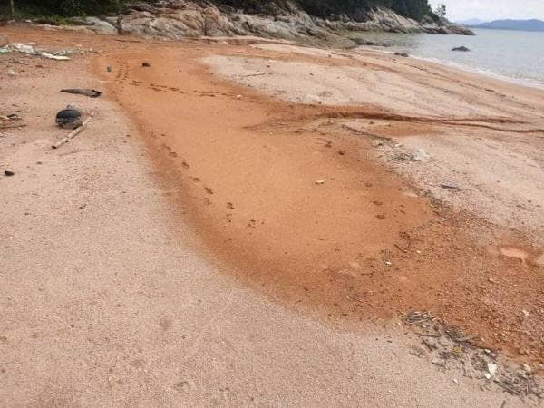 Keadaan persisir Pantai Teluk Akuan yang dicemari tanah merah. - Foto FB Otai Manjung