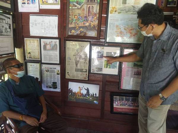 Tunku Mansor (kiri) melihat artikel ditunjukkan Wan Iskandar Zulkarnain berkaitan Istana Sepachendra di Anjung Warisan Pak Wan, Alor Setar pada Sabtu.