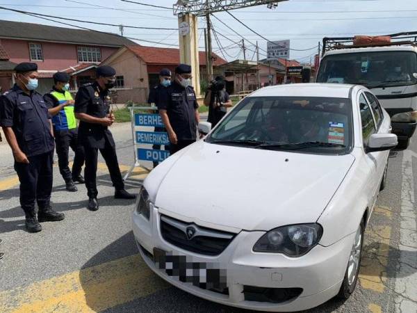Shafien (tiga dari kiri) bersama Hanif (dua dari kiri) ketika memantau sekatan jalan raya yang dilakukan di Tunjong, Kota Bharu pada Selasa.