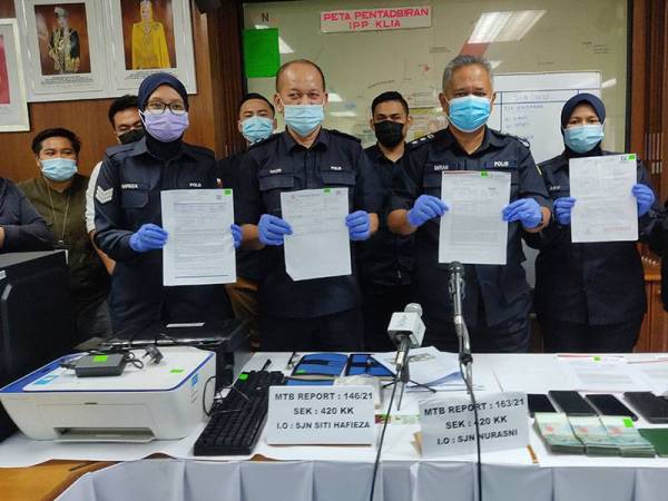 Imran (kanan, depan) menunjukkan ujian slip saringan Covid-19 palsu yang dirampas susulan tumpasnya sindiket Geng Habib baru-baru ini.