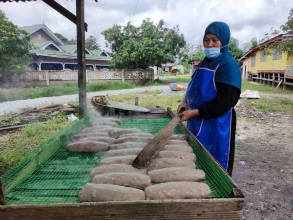 Hasmah melihat keropok yang baru diangkat dari periuk sebelum ia dibungkus.