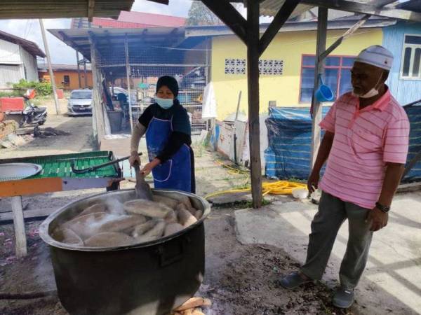 Hasmah bersama suaminya, Endut melihat keropok yang direbus selama dua jam menggunakan kayu api.