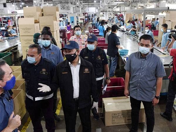 Awang Hashim (tiga dari kiri) melawat sebuah kilang membuat kasut di kawasan perindustrian Bukit Tengah semasa menyertai operasi penguatkuasaan pematuhan Akta Standard Minimum Perumahan, Penginapan dan Kemudahan Pekerja 1990 (Akta 446) hari ini. - Foto Bernama