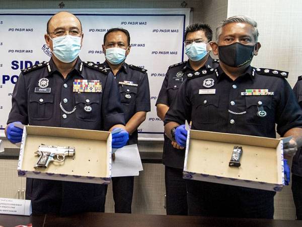 Ketua Polis Kelantan, Datuk Shafien Mamat (kiri) menunjukkan sepucuk pistol lapan butir peluru hidup serta selaras senapang angin pada sidang media di Ibu Pejabat Polis Daerah (IPD) Pasir Mas hari ini. - Foto Bernama