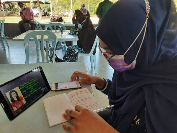 Tengku Nur Alia sedang mengikuti pembelajaran PdPR di Dewan PAWE, Balik Pulau pada Jumaat.