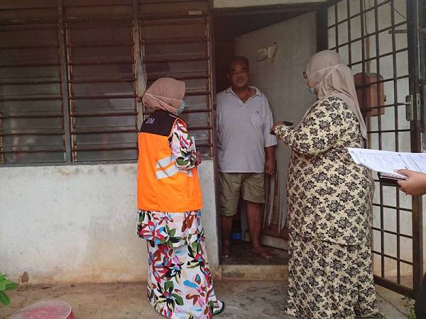 Fariza (kanan) bersama kakitangan JKM Daerah Melaka Tengah, ketika melawat Mohd Nasir di rumahnya di Taman Seri Telok Mas, Melaka pada Jumaat.