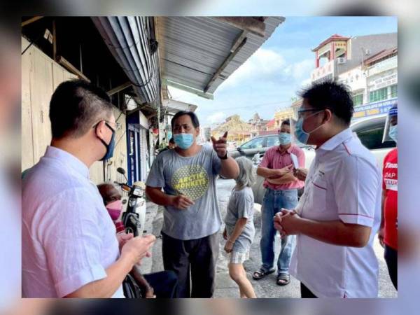 Kor Ming (kiri) mendengar keluhan peniaga berikutan pengumuman kadar baharu sewaan yang dikenakan oleh MPTI. - Foto ihsan DAP Perak