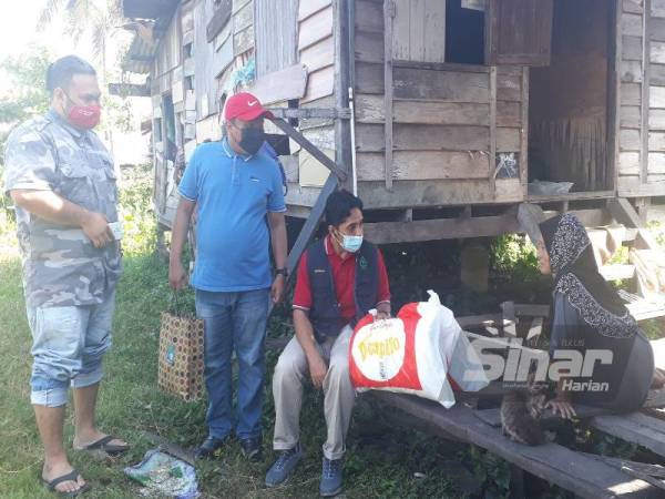 Rokhimah (kanan) ketika menerima kunjungan Hazwan (dua kanan) dan Amirul Syahir di rumahnya di Lorong Ayer Puteh, Jalan Pegawai, Alor Setar pada Ahad.