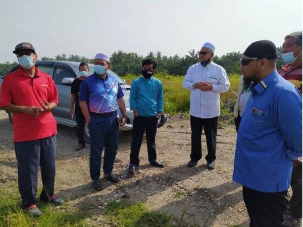 Razman (tiga dari kanan) meninjau kawasan tanah yang dibangunkan untuk ternakan udang yang dibantah penduduk di sini pada Ahad.