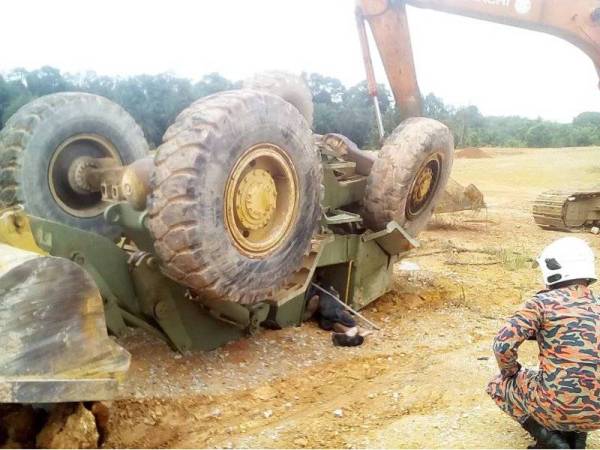 Anggota bomba menggunakan sebuah eskavator untuk melakukan kerja-kerja menyelamat dua mangsa yang terperangkap di bawah traktor terbalik di kawasan pembinaan di Jalan Kelah, Kampung Sungai Kulai, Kulai pada Isnin.