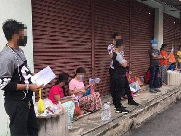 Warga Myanmar yang dikesan memakai gelang kuarantin ketika membeli stok makanan di kedai runcit di Taman Kota Jaya, Kota Tinggi pada Isnin.