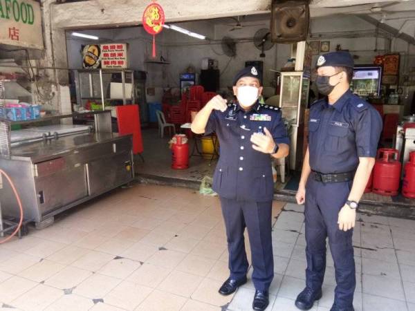 Anuar (kiri) meninjau lokasi kejadian insiden tembakan di Taman Tun Dr Ismail di sini pada Selasa.