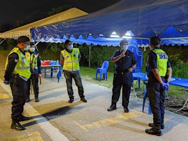 Imran (tiga dari kiri) turun padang melawat anggota yang bertugas di sekatan jalan raya ketika PKP di sekitar KLIA.