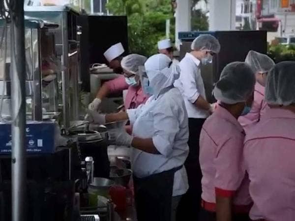 Pekerja Red Rock Hotel menyediakan makanan untuk dijual di kaki lima hotel terbabit.