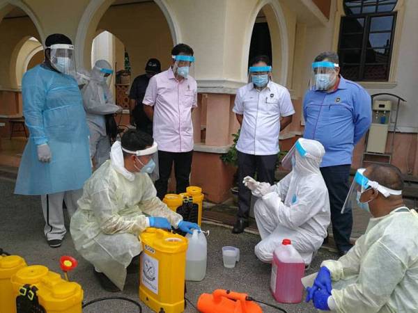 Bazlan (berdiri, tiga dari kanan) melihat persediaan pasukan disinfeksi sebelum melakukan sanitasi di Masjid Kampung Bukit Cempaka di Batu Rakit, Kuala Nerus.
