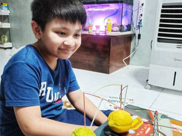 Iman menghasilkan arus eletrik menggunakan buahan-buahan hasil uji kaji yang dpelajarinya di Youtube.