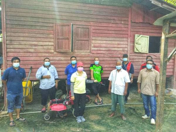 Senapi (dua dari kanan) bersama Hwee Yiam (tenga) semasa melaksanakan gotong-royong pasca banjir.