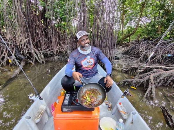 Selvakumar memasak ikan siakap lada hitam semasa memancing di Kampung Sitiawan.