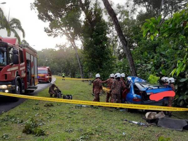 Anggota bomba mengeluarkan pemandu yang tersepit selepas melanggar sebatang pokok berhampiran Litar Pasir Gudang, Pasir Gudang pada Jumaat.