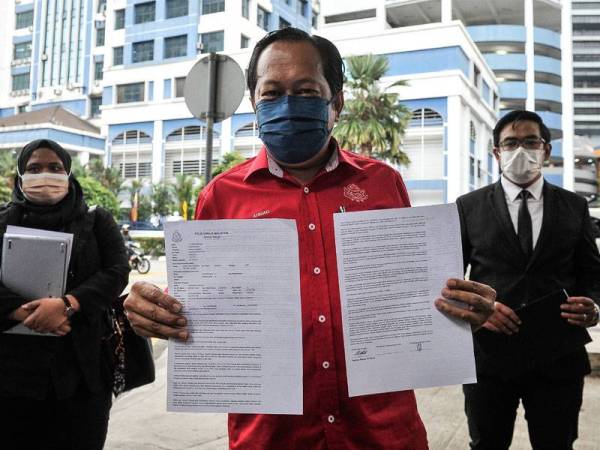 Ahmad menunjukkan laporan polis ketika ditemui pemberita selepas membuat laporan polis itu terhadap Tommy Thomas. -Foto Bernama