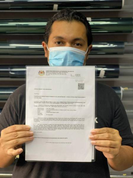 Mohd Hafizee menunjukkan surat kebenaran operasi MITI. 