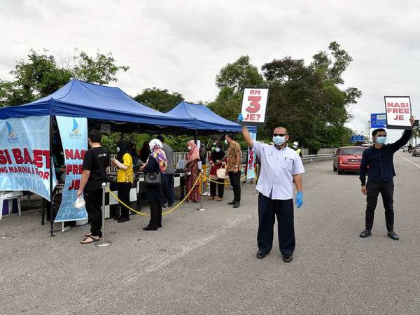Pengurus Besar Duyung & Marina Resort (DMR), Wan Mohd Faizul Wan Abas (dua, kanan) bersama kakitangannya Azim Mokhtar memegang poster nasi bajet RM3 bagi menarik perhatian orang ramai untuk singgah di gerai nasi bajet di Jambatan Sultan Mahmud, hari ini.