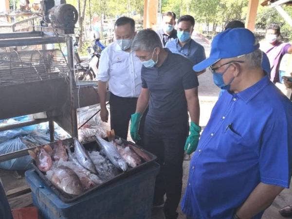 Tengku Zafrul (tengah) diiringi Pengerusi UMNO Selangor, Tan Sri Noh Omar (kanan) dan Rizam (kiri) pada lawatannya ke Jeti Nelayan Kampung Empat Simpang Bagan Nakhoda Omar, Sabak Bernam pada Ahad.