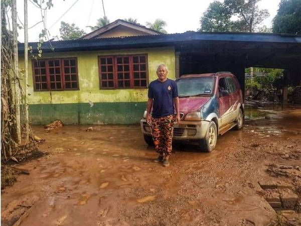 Long Rofik di hadapan rumahnya selepas banjir yang melanda Kampung Paya Chedong surut. 