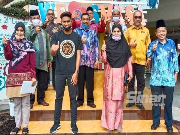 Adli (depan, dua dari kiri) berkongsi kegembiraannya bersama guru-guru SMK Sri Aman.