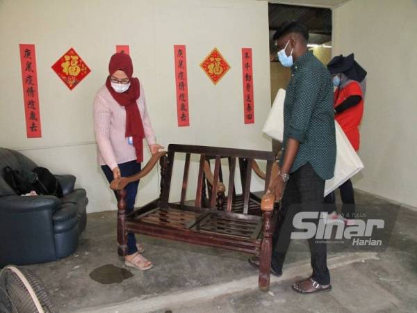 Kumaran (kanan) membantu menyusun atur perabot dalam rumah Lean Ngang sempena sambutan Tahun Baru Cina yang bakal menjelang.