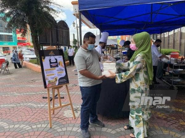 Raja Rusmin membantu pekerjanya berniaga di reruai di hadapan Hotel The Grand Renai, Kota Bharu bagi menambah pendapatan dan mengelak pembuangan pekerja.